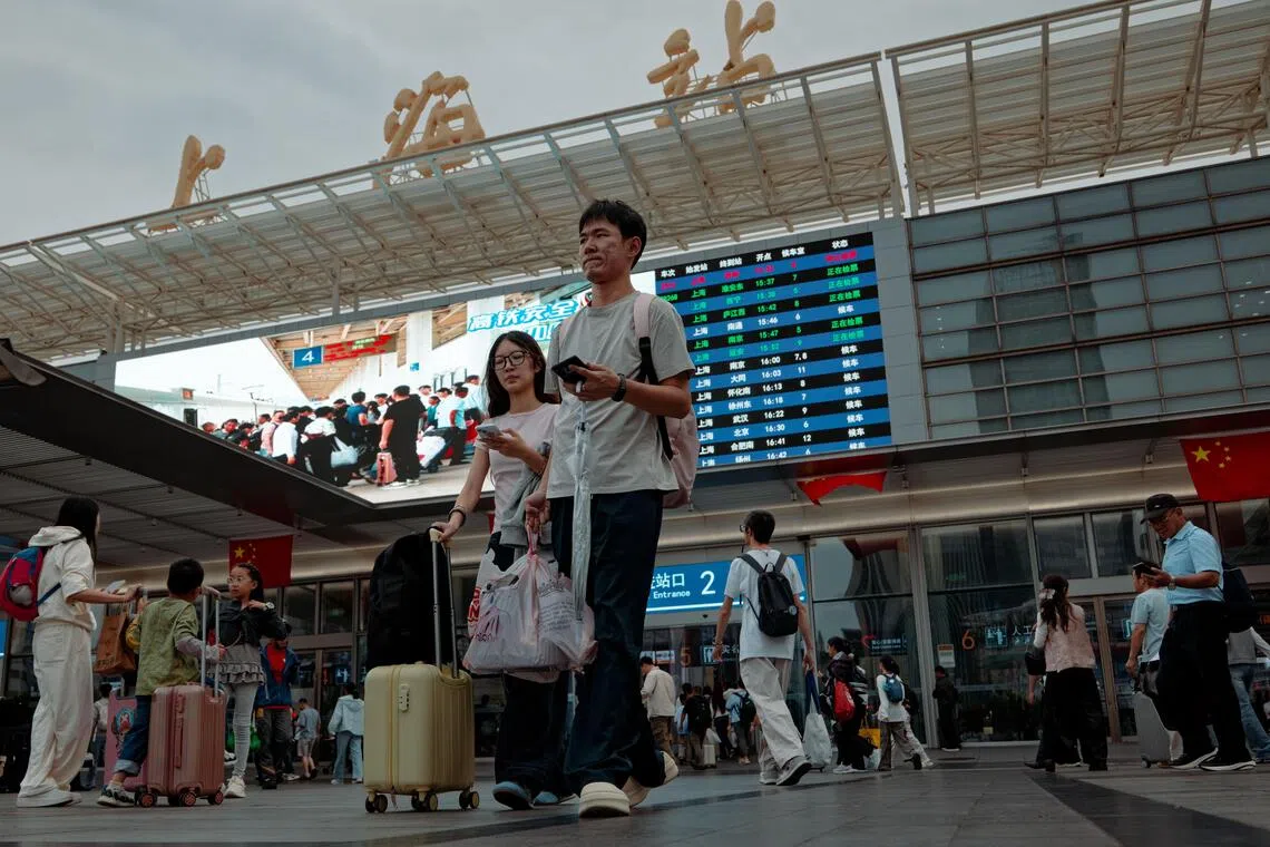 epa13274231 Travelers walk at a railway station during China's National Day holiday travel rush in Shanghai, China, 01 October 2026. The National Day holiday runs from 01 to 07 October 2026, a period of increased domestic travel across China. According to China's Ministry of Transport, about 2.13 billion cross-regional trips are expected during the seven-day holiday. EPA/ALEX PLAVEVSKI