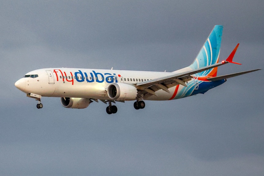 A plane with the words 'flydubai' on the side in the air.